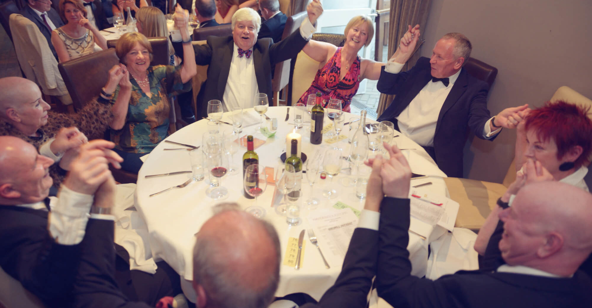 Chamber members sitting around a round table and dancing